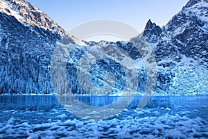 Winter landscape of snowy rocky mountains and ice lake. Winter natural background