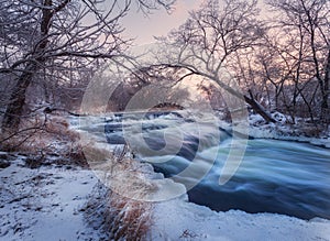 Winter landscape with snowy trees, beautiful frozen river at sun