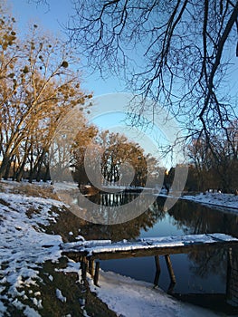 Winter landscape sunny day the Southern Bug River, pier in the snow. Ukraine