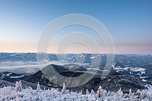 Winter landscape before sunrise from Velky Choc mountain in winter with fog in valley, with view of low and high Tatras and