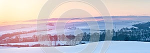 Winter landscape, sunset over the hills near the national road, view of the snow-covered fields