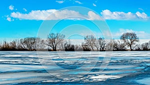 Winter landscape with trees near the ice covered river