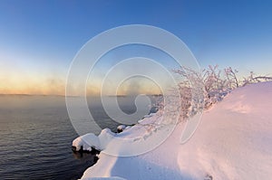 Winter landscape on Ural lake with fog and snow on the shore, Russia, January