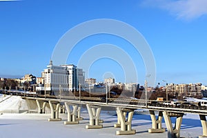 Winter landscape, urban bridge across the river on a sunny day.