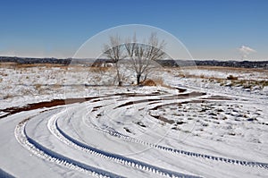 Winter landscape with vehicle tracks in snow