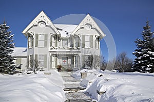 Winter landscape of Victorian-style house exterior with deep snow in winter