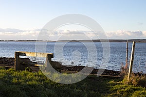 Winter landscape, Wales. Seascape, bench at the waters edge with view over the bay.