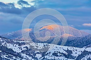 Winter landscape. Winter natural background. Mountains with snow covered hills and sunny peaks