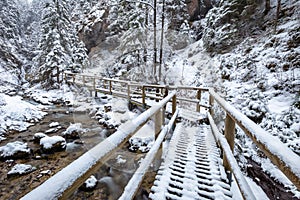 Zimní krajina s dřevěným mostem na turistické stezce