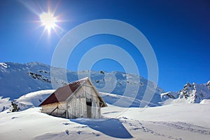 Winter landscape with wooden toolshed at Balea lake, Sibiu county, Romania.