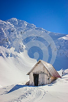 Winter landscape with wooden toolshed at Balea lake, Sibiu county, Romania.