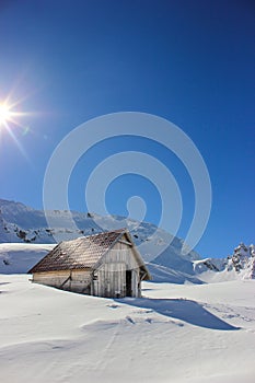 Winter landscape with wooden toolshed at Balea lake, Sibiu county, Romania.