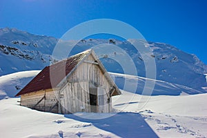 Winter landscape with wooden toolshed at Balea lake, Sibiu county, Romania.