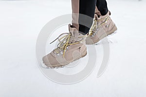 Winter leather stylish woman`s boots with yellow laces. Female fashion. Stylish shoes. Close-up.