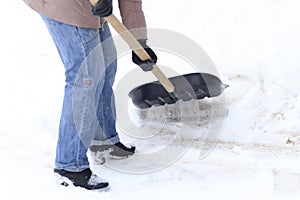 Winter is a lot of snow. A young girl, cleans, proud of doing the big shovel work