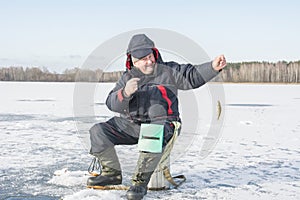 In winter, a man fishes on a frozen river