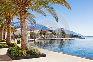 Winter in Montenegro. Embankment of seaside Tivat town with Lovcen mountain in the background photo