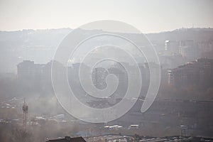 Winter morning atmosphere view on landscape of houses and buildings with fog covered street. Environmental disaster.