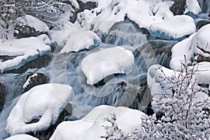 Winter mountain creek cascades and snowfall