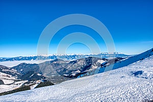 Zimní horská krajina s mlhou v údolí a Vysoké Tatry v pozadí. Tatry