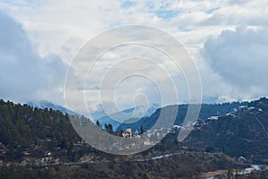 Winter mountain landscape. Small town between mountains. A cloud hangs over the city