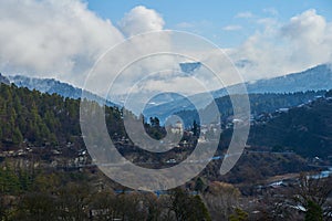 Winter mountain landscape. Small town between mountains. A cloud hangs over the city