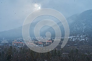 Winter mountain landscape. Small town between mountains. A cloud hangs over the city