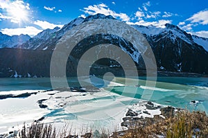 Winter mountain landscape with snow covered mountain peaks and frozen ice lake