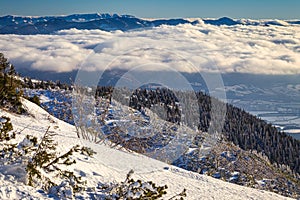 Winter mountain landscape at a sunny day with fog in the valleys