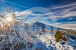 Winter mountain landscape at a sunny day with fog in the valleys