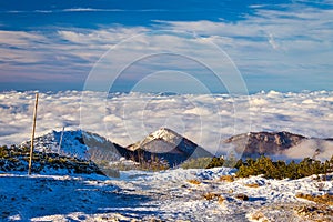 Winter mountain landscape at a sunny day with fog in the valleys