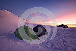 Winter mountain landscape. Tent in sunset light. Tents in the snow - Piatra Mare Mountains, landmark attraction in Romania