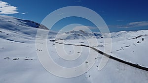 Winter mountain pass road cutting throught white winter landscape surrounded by tall peaks on the Kaperdalen mountain on the islan