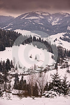 Winter mountain village landscape with snow and houses.