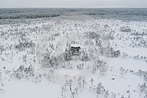 Winter nature scene of Estonia. Observation tower on the Viru raba in winter day. Drone view