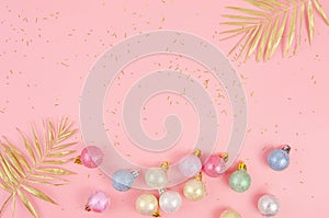 Winter New Year background. Multicolor Christmas Tree balls on pink
