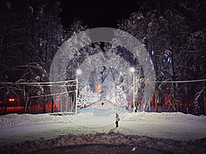 Winter New Year park, illuminated with garlands. A lonely girl is waiting for someone.