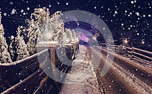 Winter night scene. starry sky over snowy road and mountain cottage, Christmas holidays, and tourism concept. rural winter