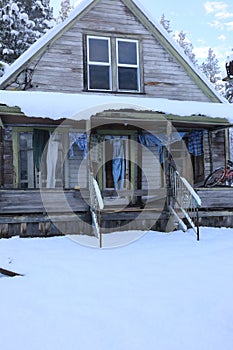 Winter old American Country landscape with rustic houses, cars and fences covered in snow