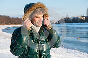 Winter outfit. Hipster winter fashion outfit. Guy wear jacket with hood on frosty winter day. Man bearded stand warm