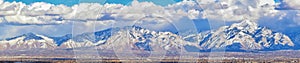 Winter Panoramic view of Snow capped Wasatch Front Rocky Mountains, Great Salt Lake Valley and Cloudscape from the Bacchus Highway