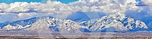 Winter Panoramic view of Snow capped Wasatch Front Rocky Mountains, Great Salt Lake Valley and Cloudscape from the Bacchus Highway