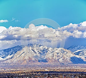 Winter Panoramic view of Snow capped Wasatch Front Rocky Mountains, Great Salt Lake Valley and Cloudscape from the Bacchus Highway