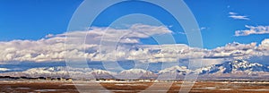 Winter Panoramic view of Snow capped Wasatch Front Rocky Mountains, Great Salt Lake Valley and Cloudscape from the Bacchus Highway