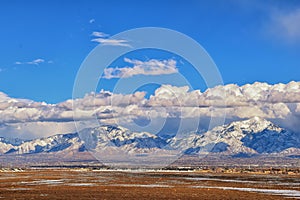 Winter Panoramic view of Snow capped Wasatch Front Rocky Mountains, Great Salt Lake Valley and Cloudscape from the Bacchus Highway