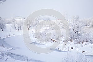 Winter Park. Bushes and trees are covered with thick frost. Visible icebound river