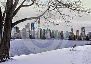 Winter park with snow and view of a downtown of Vancouver BC, Canada in the background during sunset