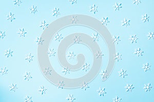 Winter pattern made of white snowflakes on blue background. Top view. Flat lay. Winter composition. Christmas, new year