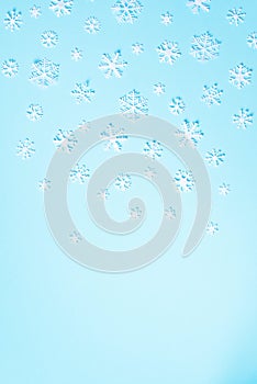 Winter pattern made of white snowflakes on blue background. Top view. Flat lay. Winter composition. Christmas, new year