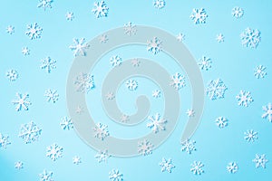 Winter pattern made of white snowflakes on blue background. Top view. Flat lay. Winter composition. Christmas, new year